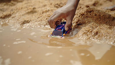 Image of hand pushing toy car into water