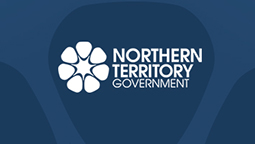 Blue back background with the Northern Territory dessert rose logo in white and Northern Territory Government in white text on the right side of it.